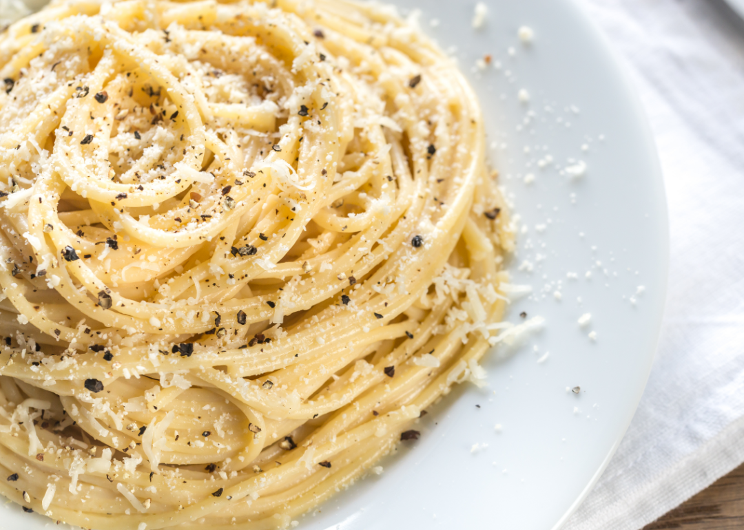 A plate of Cacio e Pepe pasta topped with freshly ground pepper