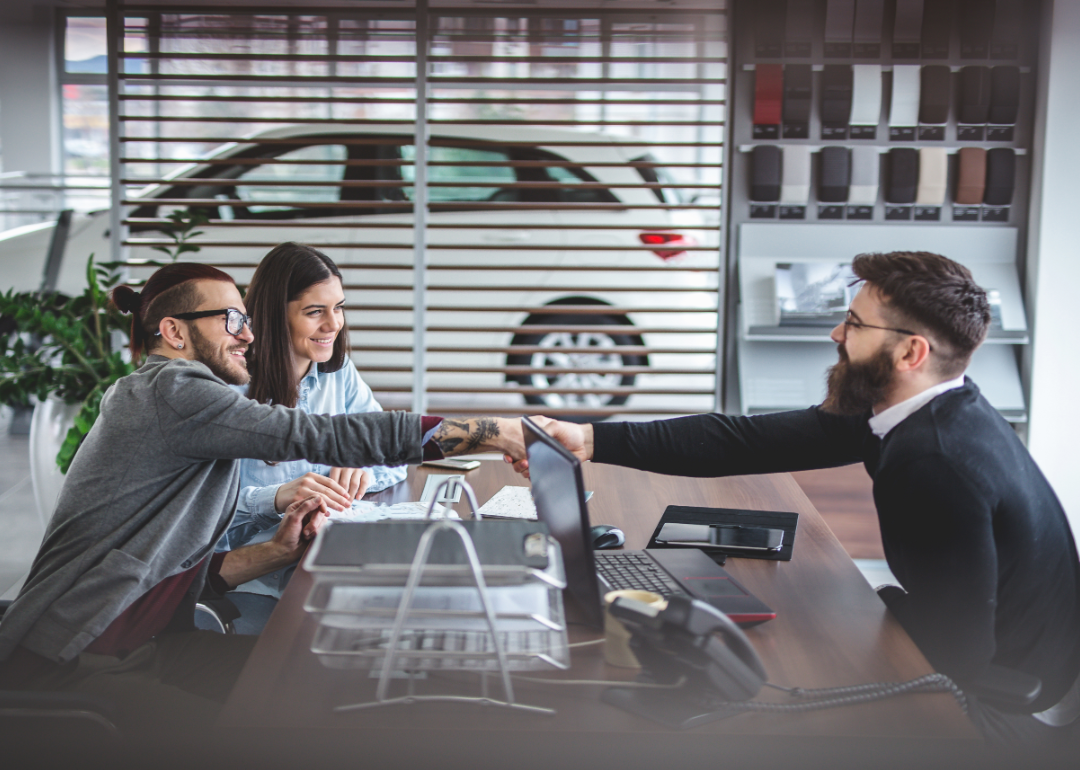 car buyers in a dealership talking to sales