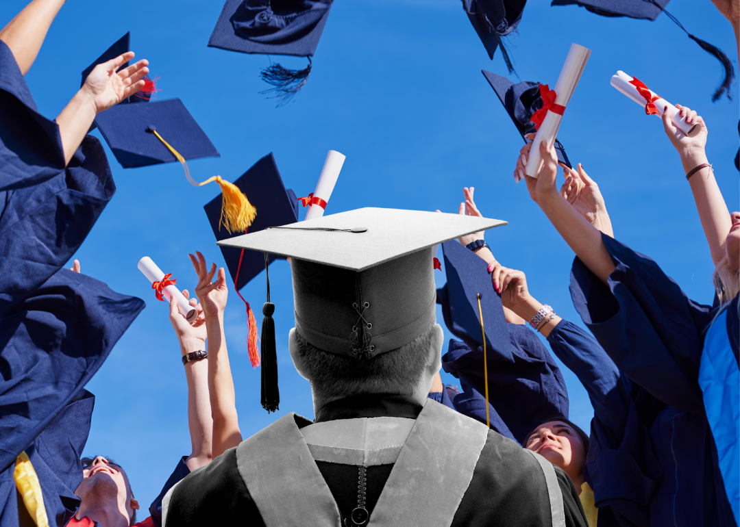 Black and white image of a colege graduate against a colorful backdrop of graduates tossing caps into the air.
