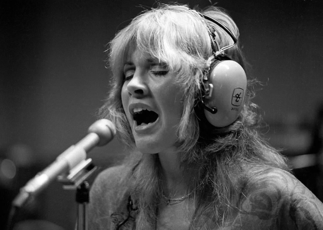 Stevie Nicks singing in the recording studio, wearing headphones.