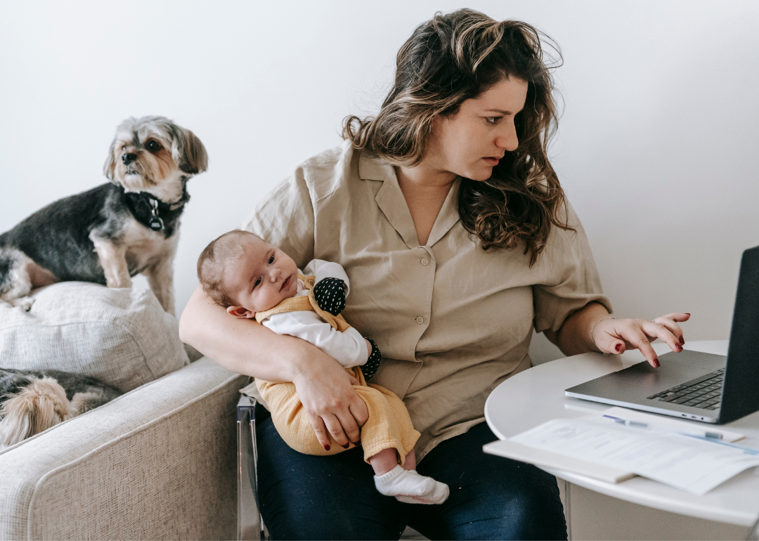parent juggling pet and baby while working from home