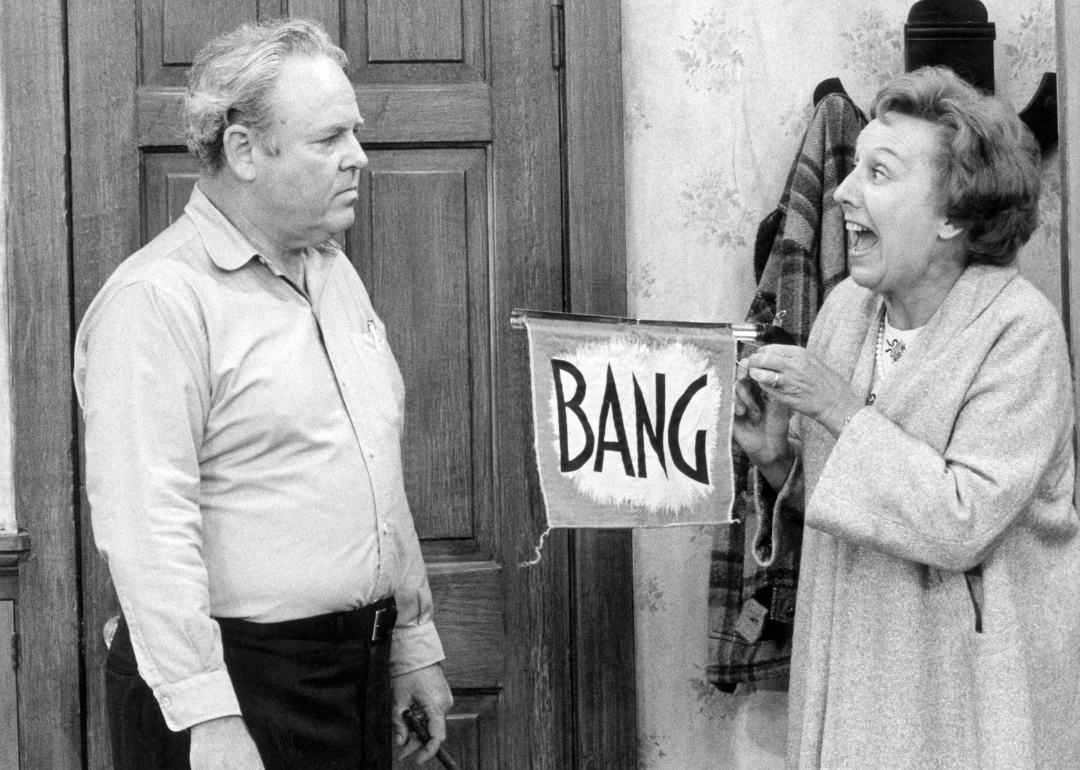 Actor Jean Staplton playing Edith holding a sign with the word "bang" in an attempt to cheer up  Archie, played by Carrol O'Connor, in an episode of 'All In The Family'