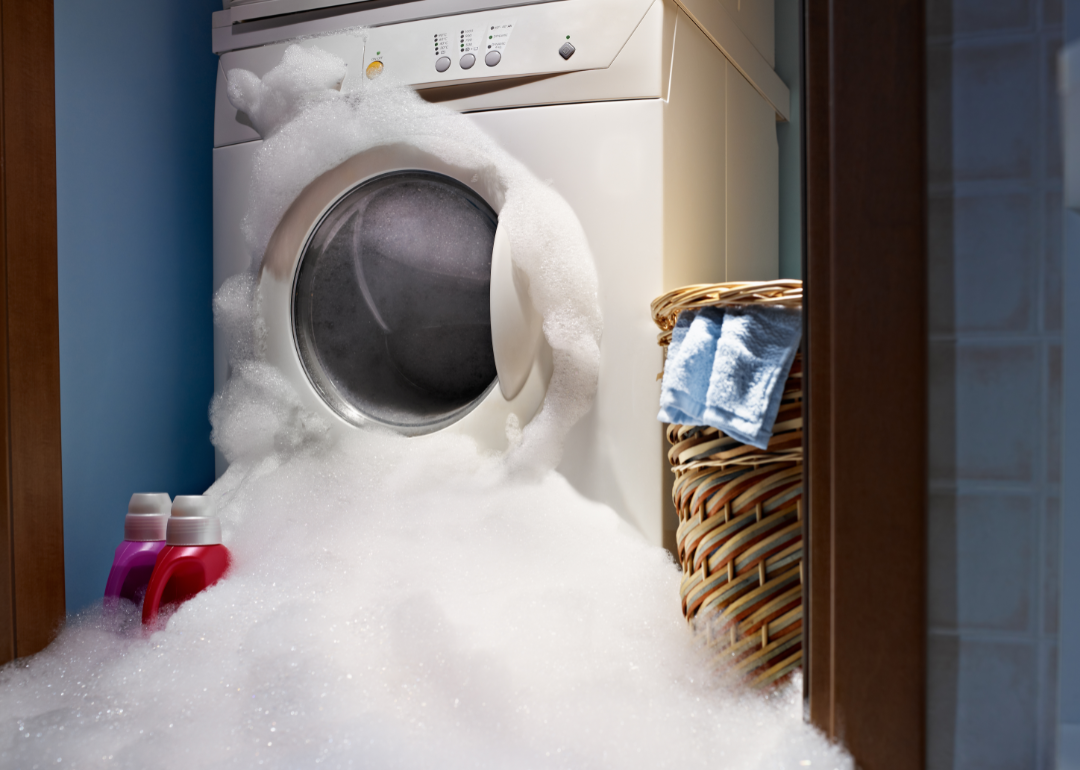 laundry machine overflowing with soap suds