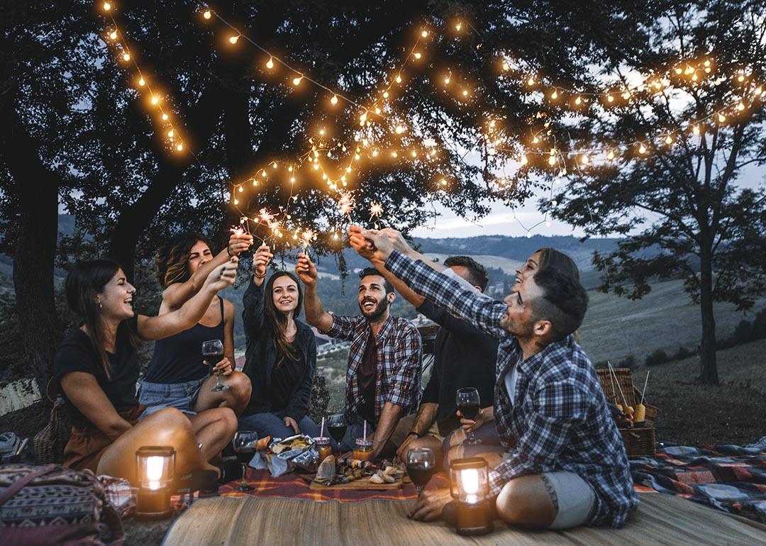 friends celebrating together outdoors on a picnic while darkness falls