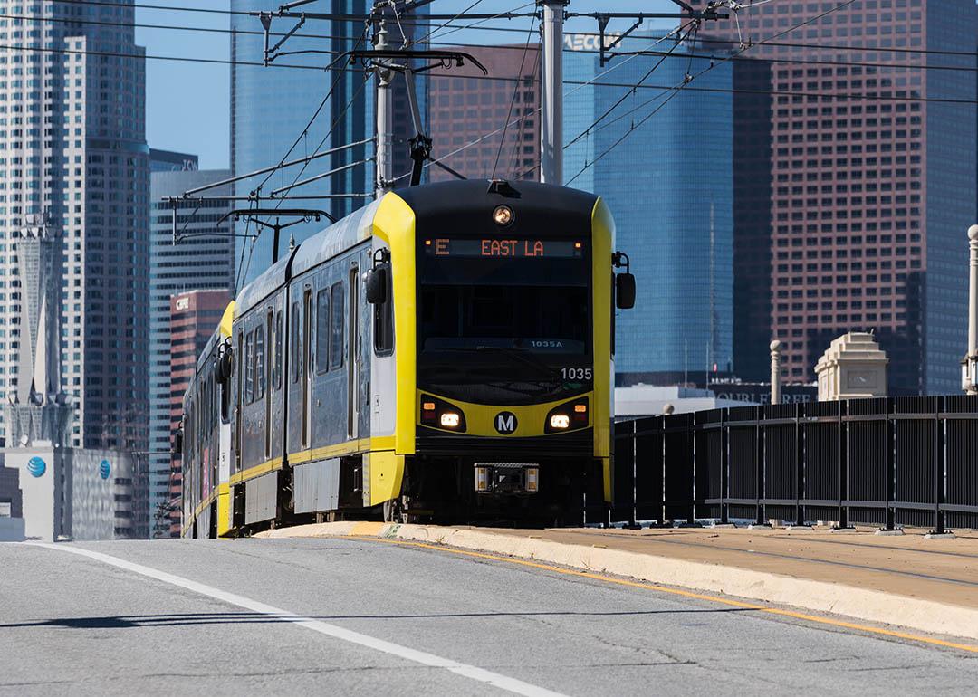 LA Metro E line train pulls into Boyle Heights with Downtown LA in the background