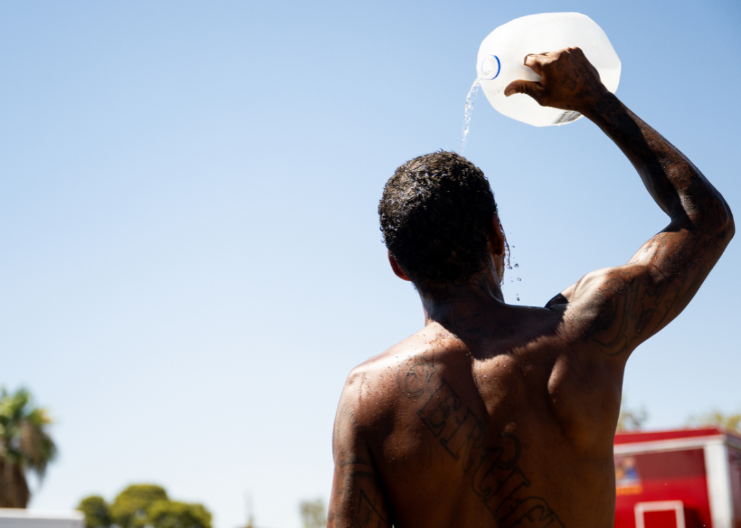 A person cools off by pouring a gallon jug of water over their head amid searing heat that was forecast to reach 115 degrees Fahrenheit on July 16, 2023 in Phoenix, Arizona.