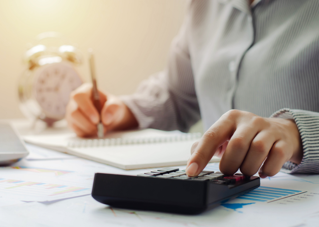 Person doing paperwork and using a calculator