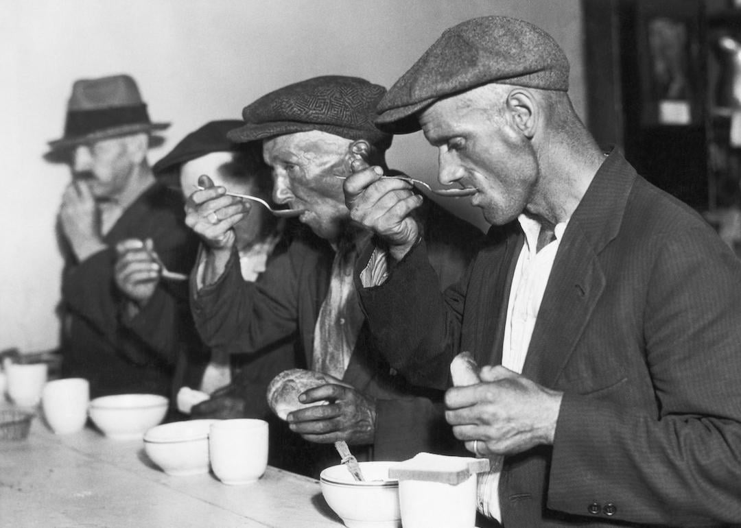 People eating bread and soup in a breadline during the Great Depression.