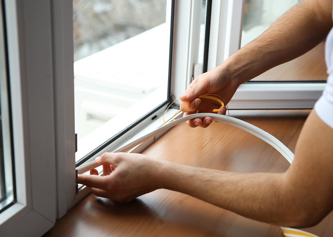A worker installing energy-efficient windows in a home.