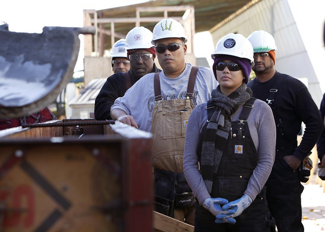 Students Marie Rowena Hall (right), Ryan Tagle (middle), and Michael Wells (left) learn how to work with concrete at JobTrain during laborers construction fundamentals training in Menlo Park, California.