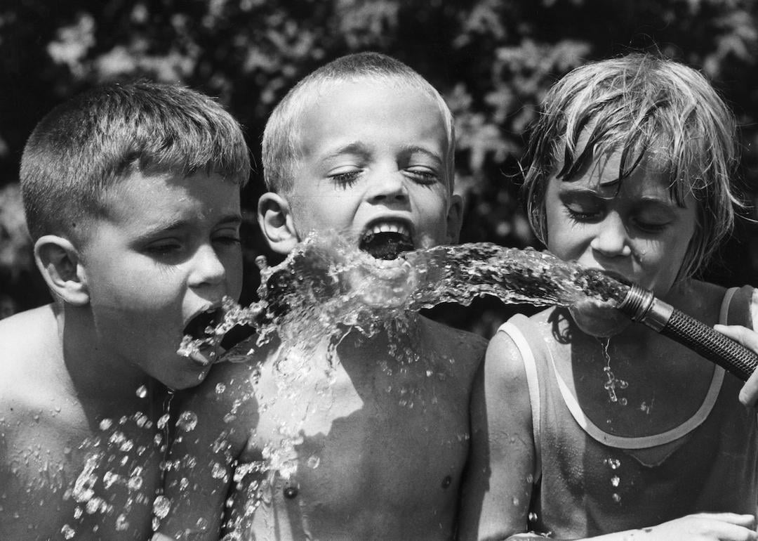 On a hot day in St. Petersburg, Florida in the 1960s, children use a garden hose to stay cool.