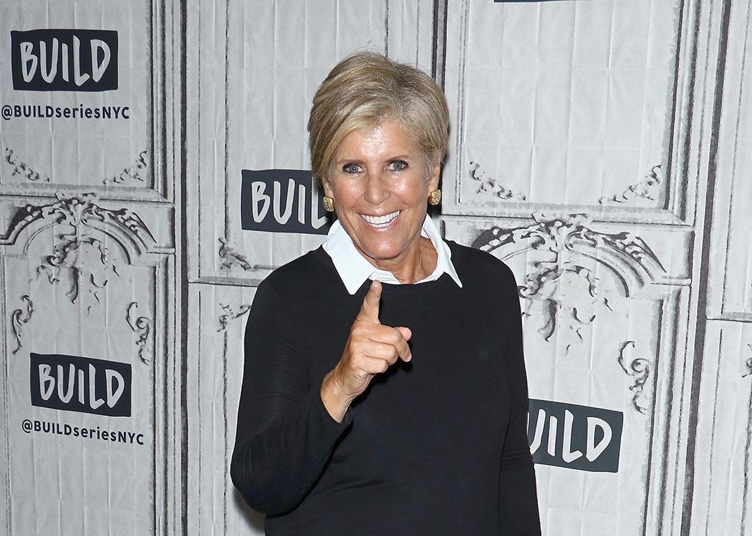 Suze Orman points at camera wearing white shirt under black sweater at an event on September 17, 2018 in New York City.