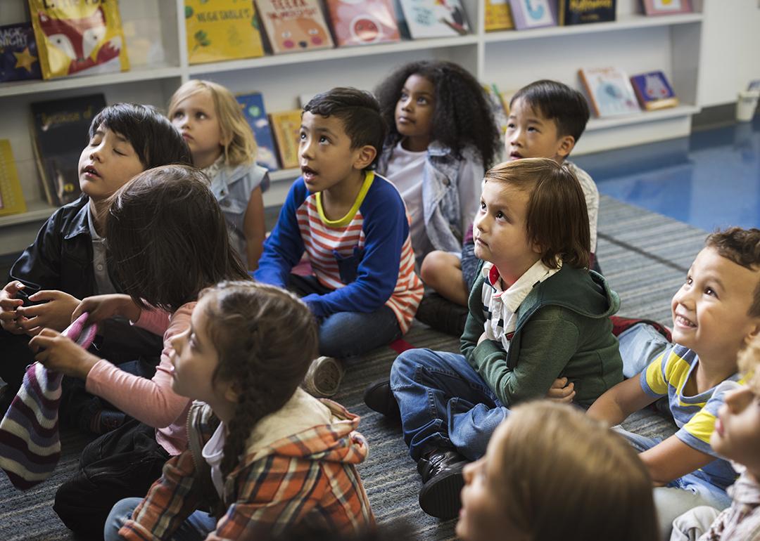 Young students sitting on the floor in a early childhood classroom.