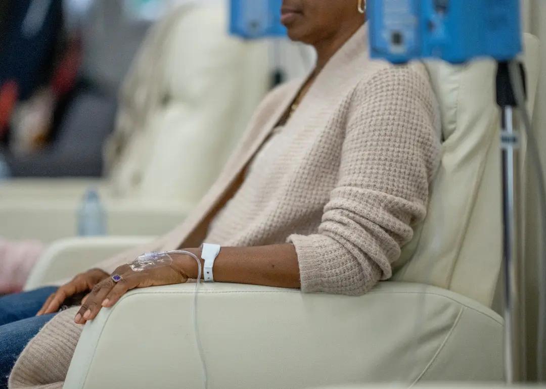 Patient sitting in chair while receiving chemotherapy treatment.
