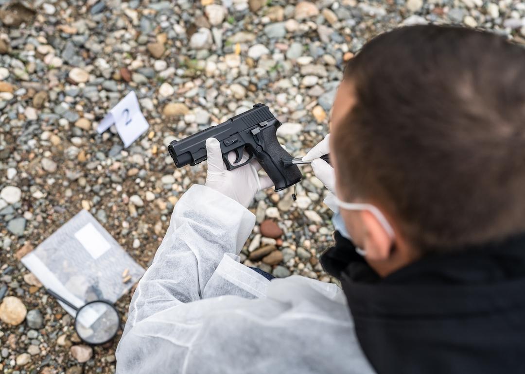 Overhead view of an investigator collecting evidence at crime scene.