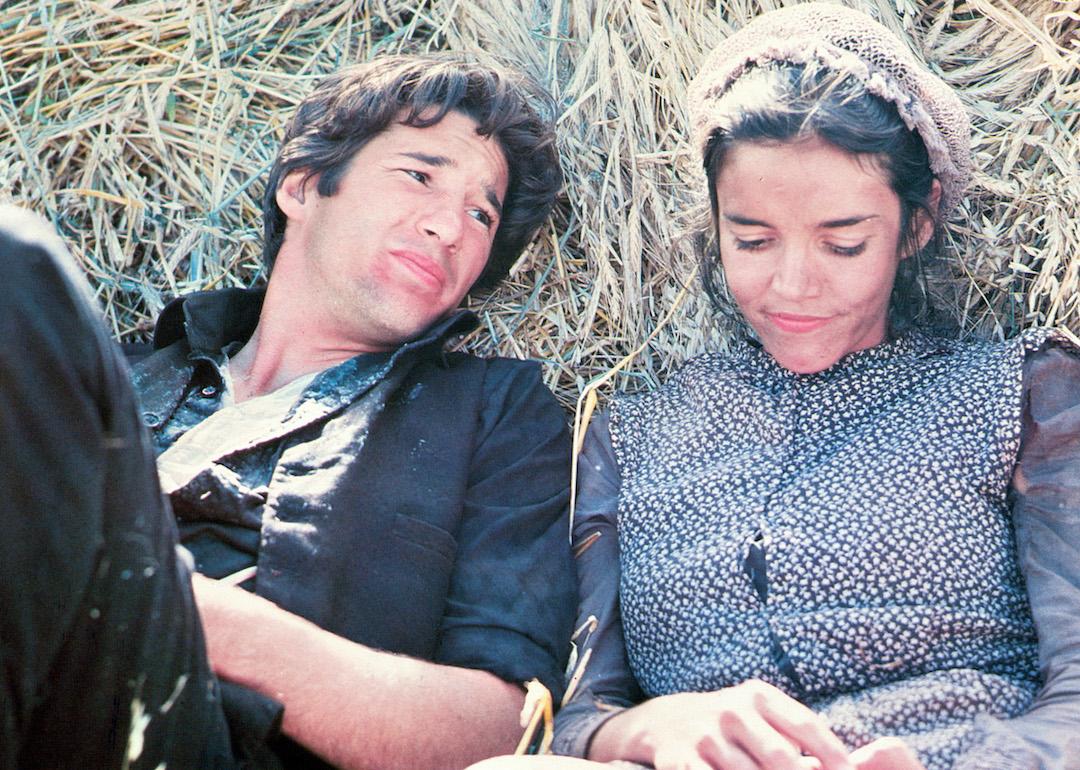 Richard Gere laying in the hay with Brooke Adams in a scene from the 1978 romance film 'Days of Heaven.'