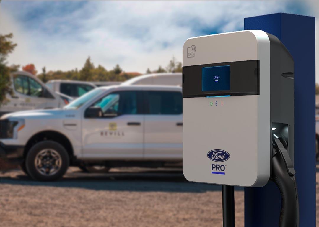 A close-up image of the Ford station pro that offers bidirectional charging with several cars in the background.