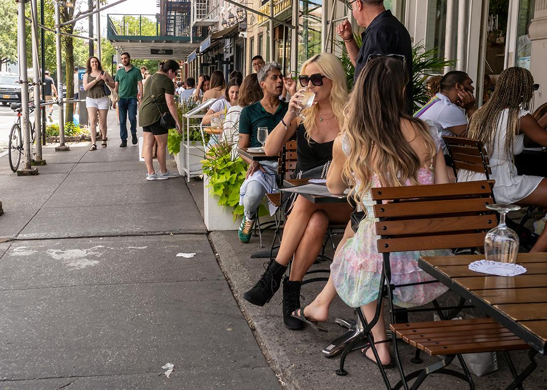 Diners during the day in a lane in New York City enjoying some alfresco dining.