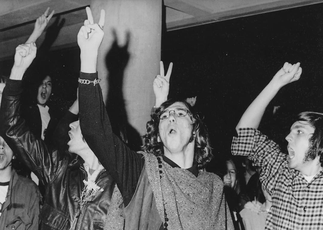 Students wearing hippie attire and holding their fingers aloft in a peace sign gesture during an anti-Vietnam War student sit-in protest at North Carolina State University in 1970.