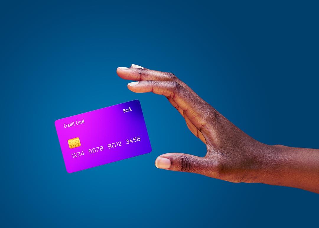 Image of a hand trying to catch a credit card mid-air.