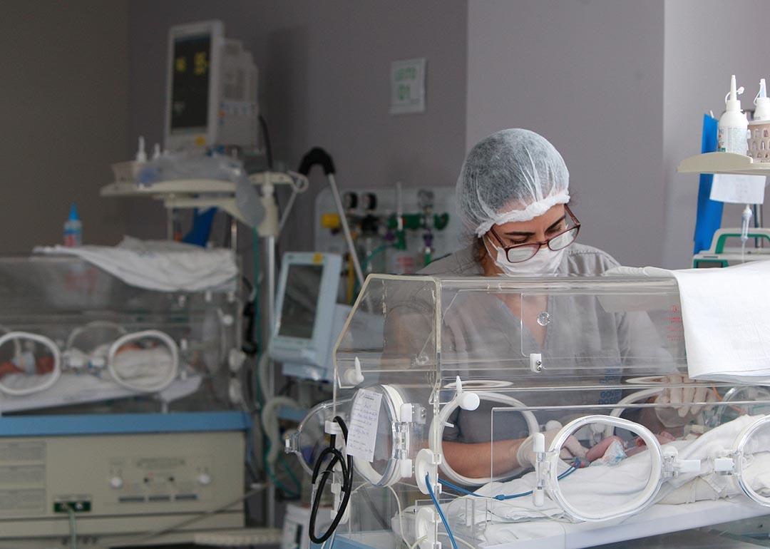 Medical professional tends to baby in NICU.