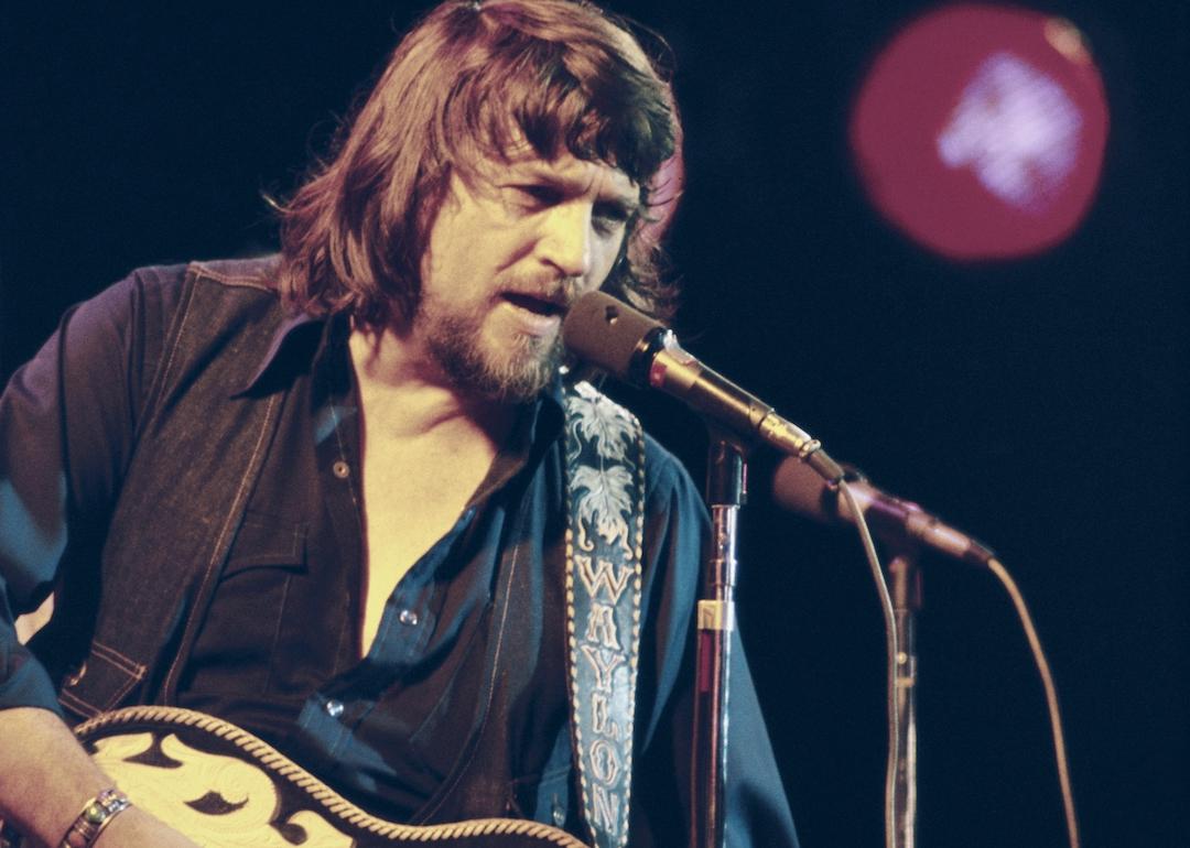 Country singer Waylon Jennings performing on stage.