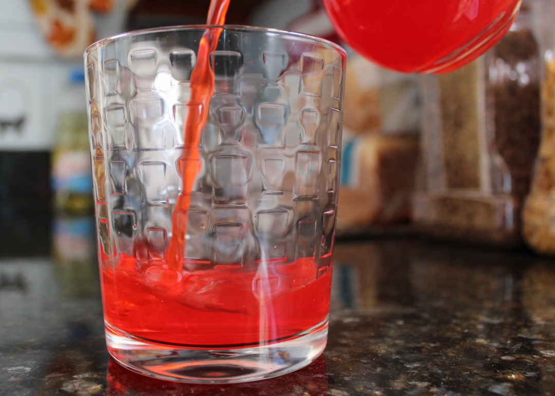 Red drink pouring into a glass