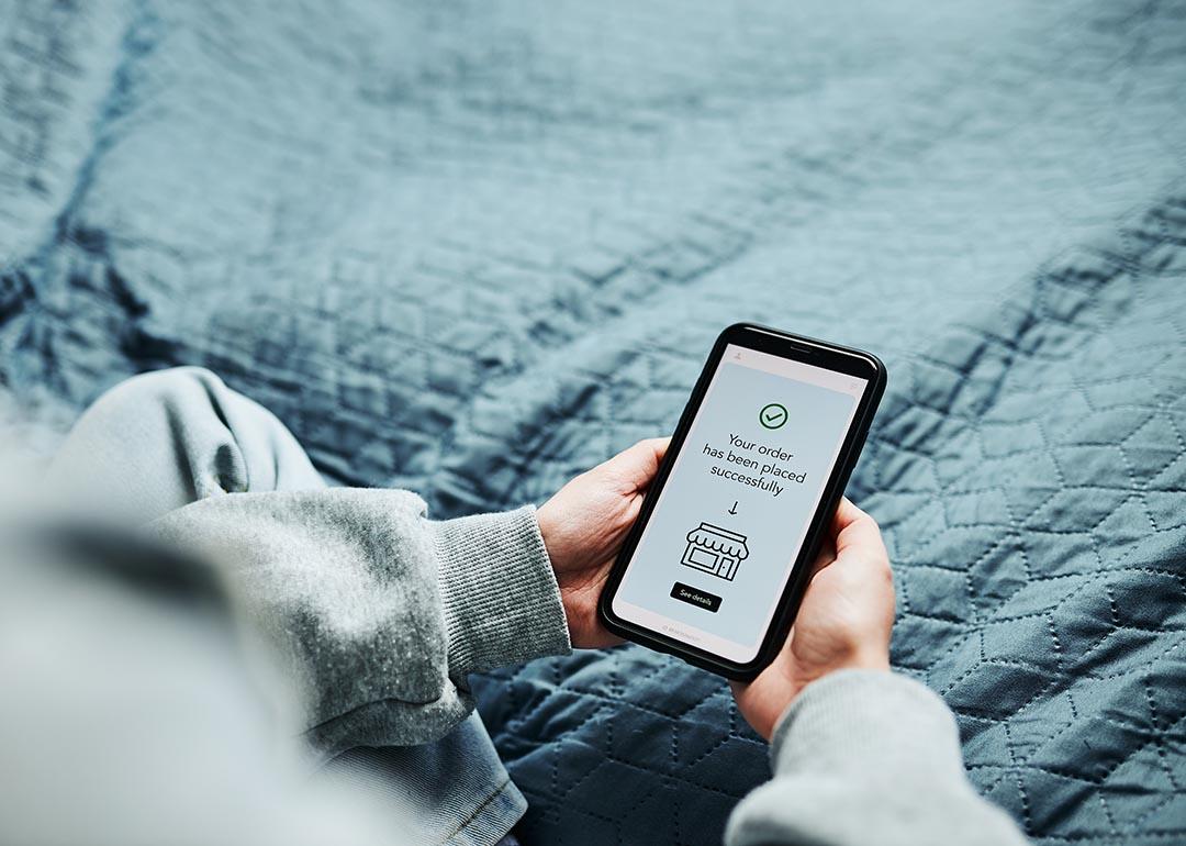 A person's hands holding a phone that displays a successful transaction.