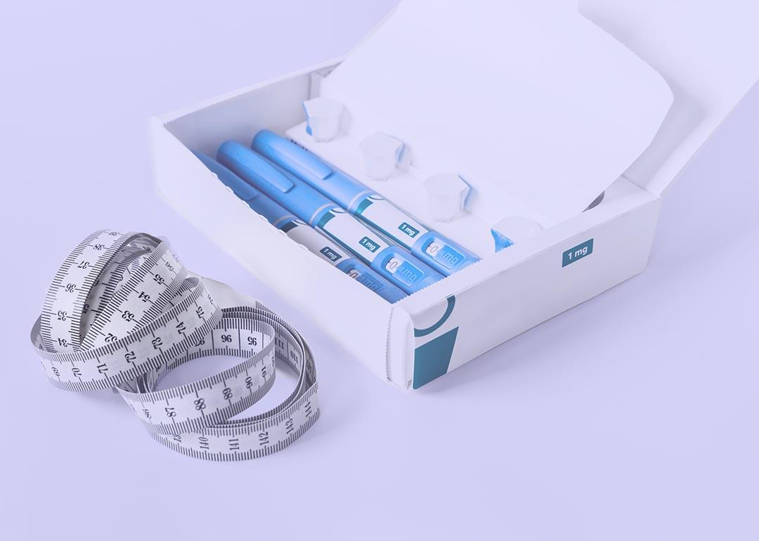 Box of semiglutide injectable drugs and measuring tape on lavendar background.