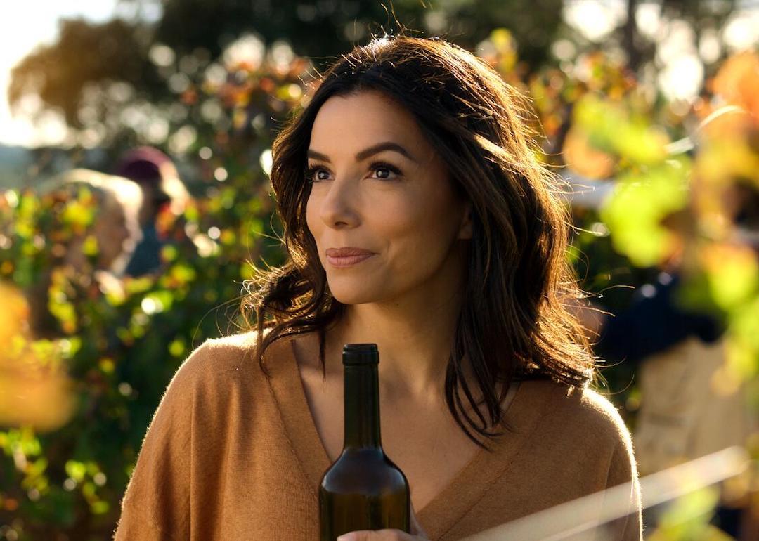 Eva Longoria holds a bottle of wine in the 2024 Apple TV+ series 'Land of Women.'