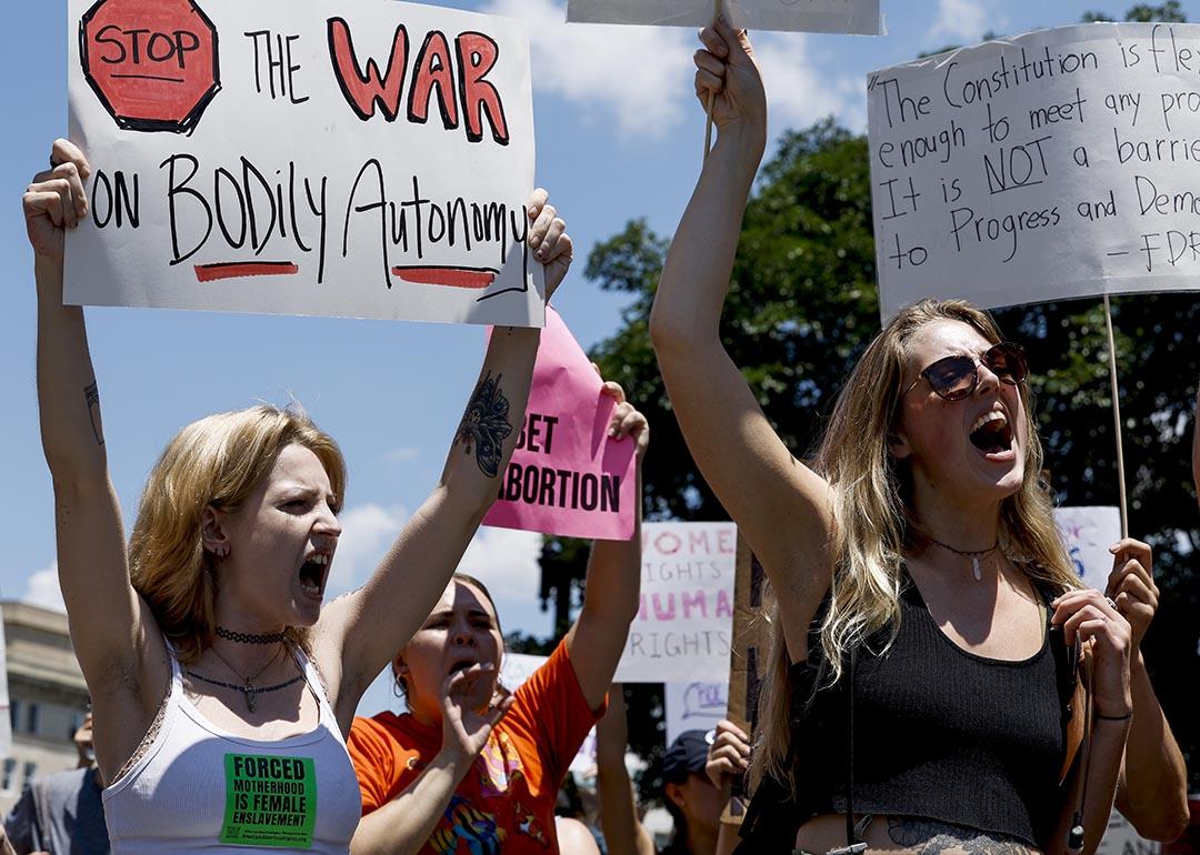 Abortion rights activists yell and hold up signs during a protest in the wake of the decision overturning Roe v. Wade outside the U.S. Supreme Court Building on June 25, 2022 in Washington, DC.