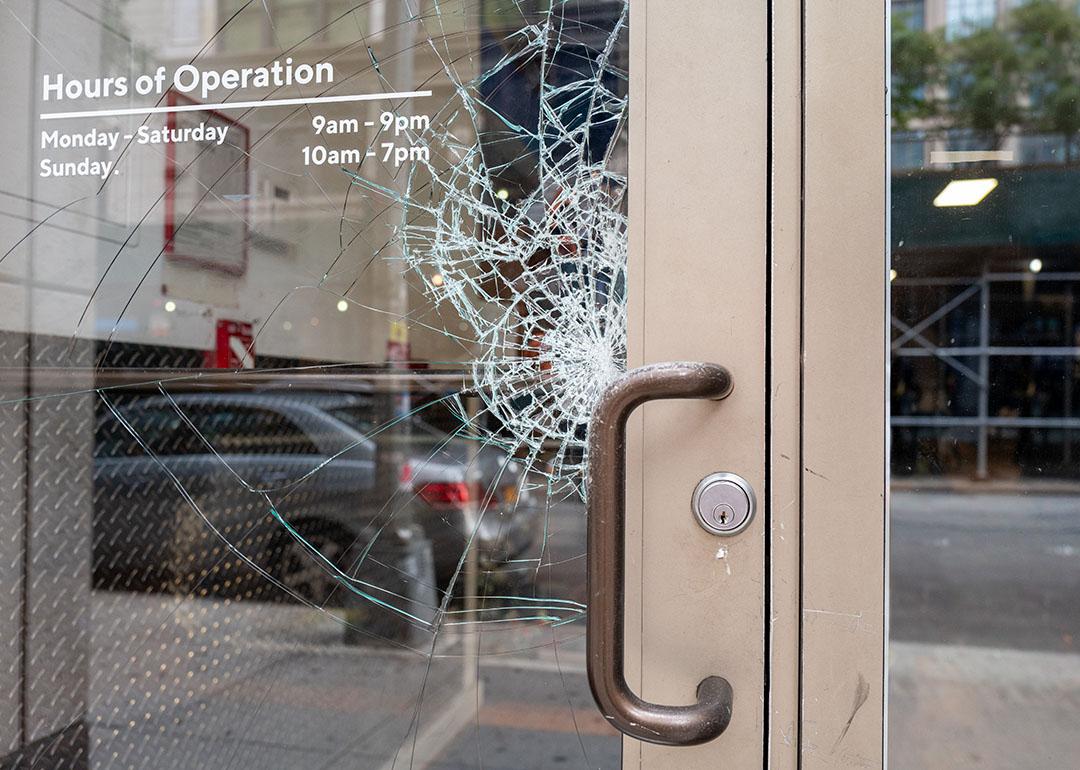 A store's glass door is cracking from damage.