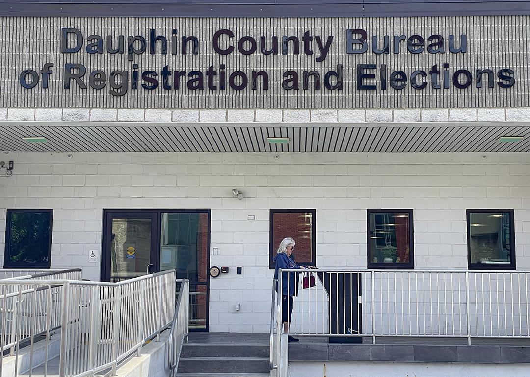 A voter places her absentee ballot in a monitored drop box in Dauphin County, PA.