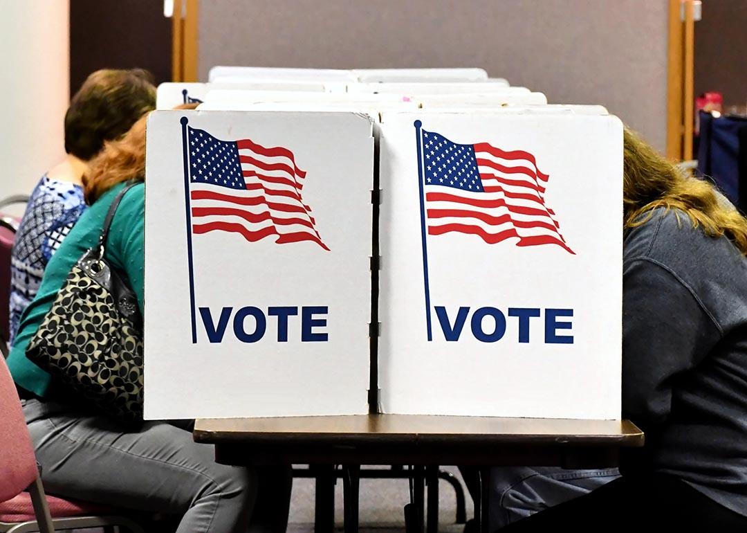 Voters sit in Virginia at a polling place, hidden by voting booth.