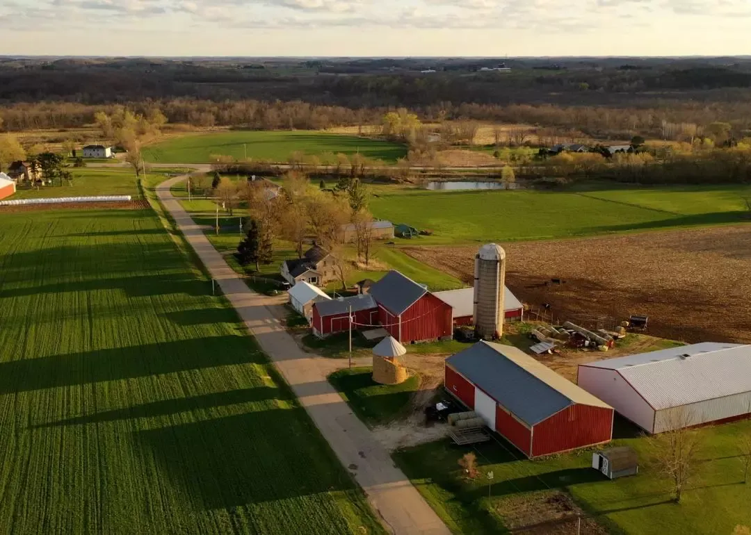 Overhead view of a rural farm with barns, storage silos and green fields