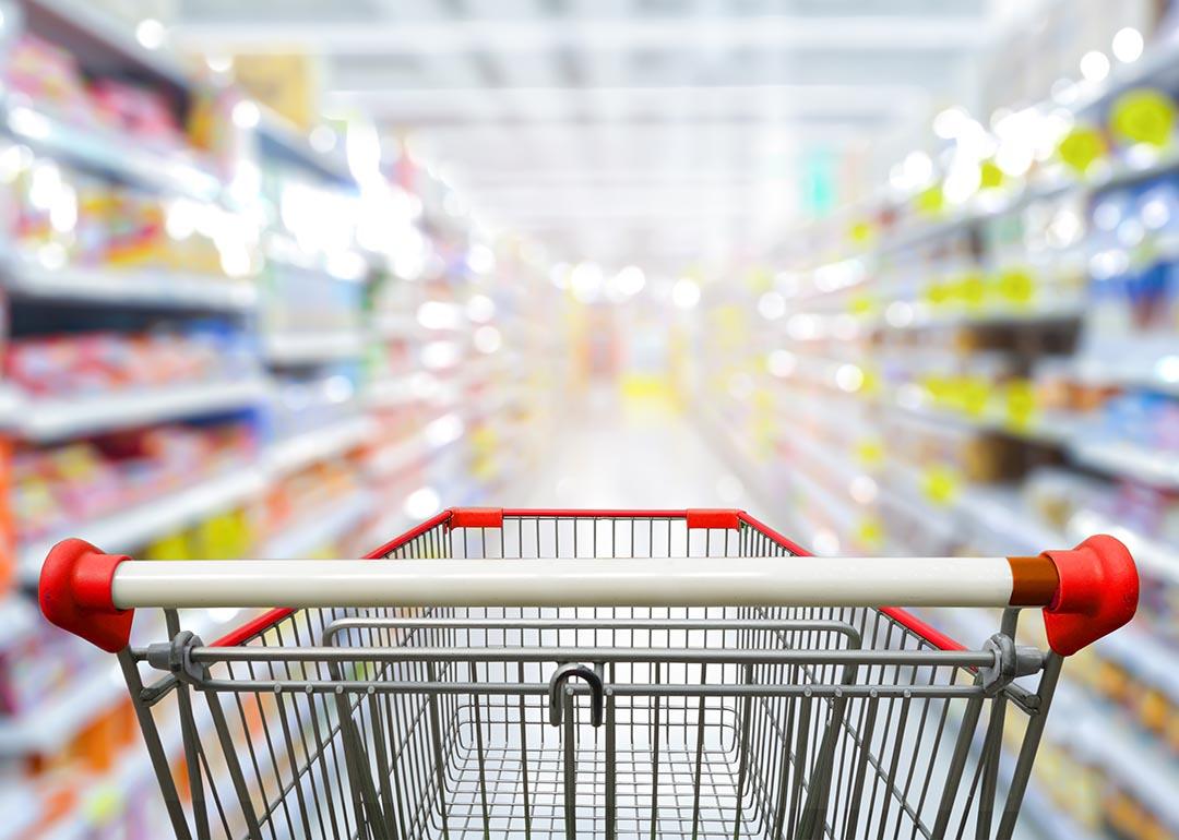 Shopping cart focusing at the center of a grocery aisle.