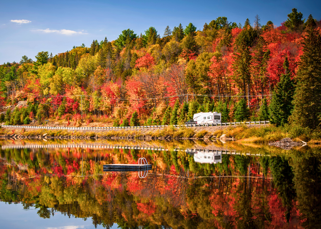 RV on road with fall foliage in the background.