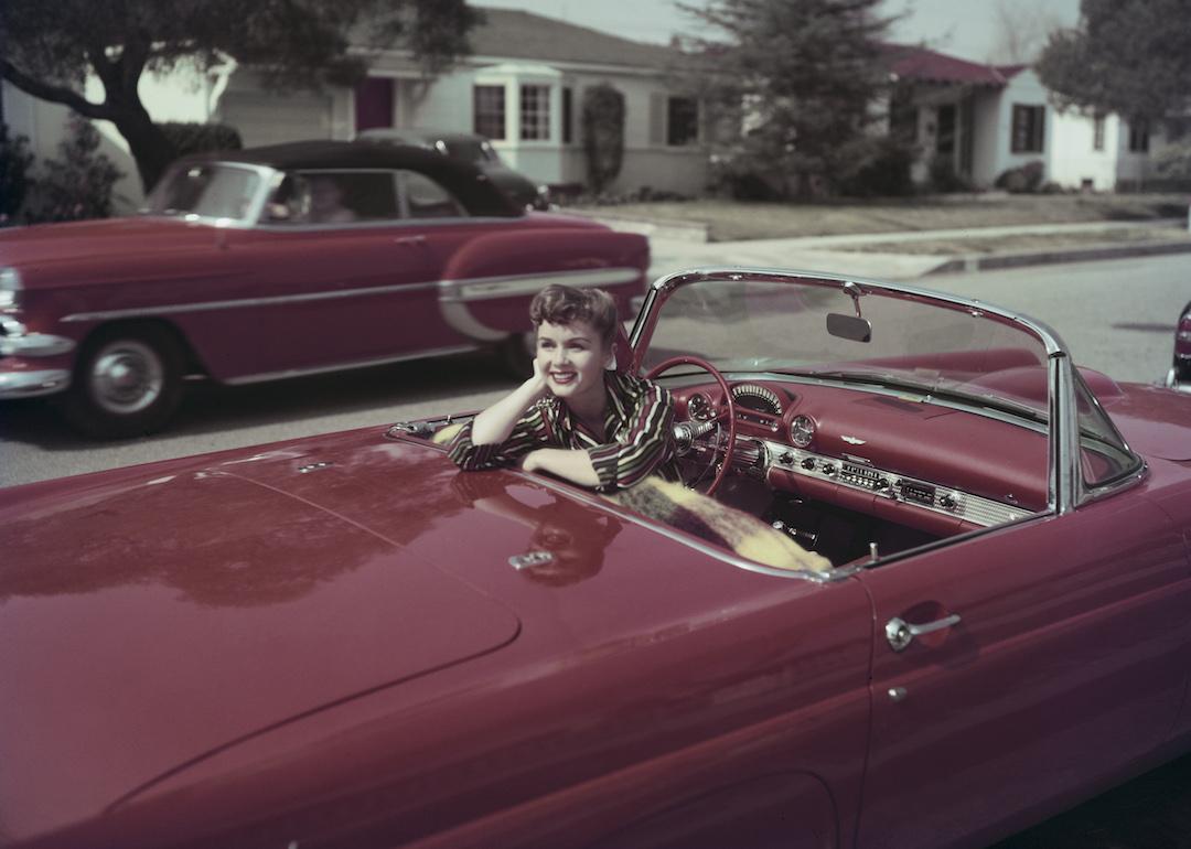 Actor and singer Debbie Reynolds sits in the driver's seat of a red convertible Ford Thunderbird, in Burbank, California, in March 1955.