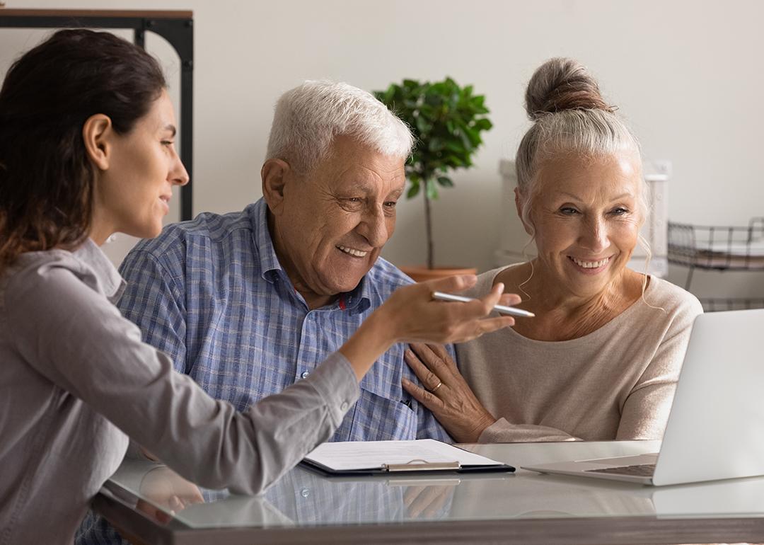 An elderly couple happily engaged in a mortgage meeting with a banking specialist.