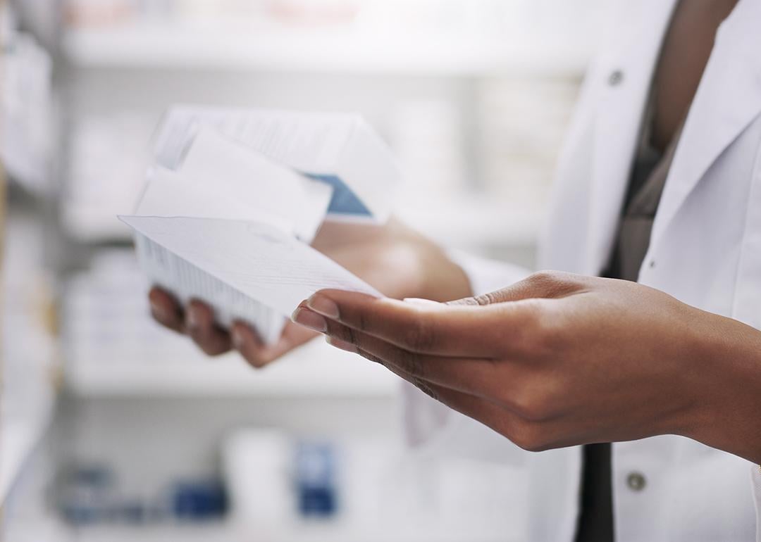 A medical professional looking through drugs and their descriptions in a laboratory.