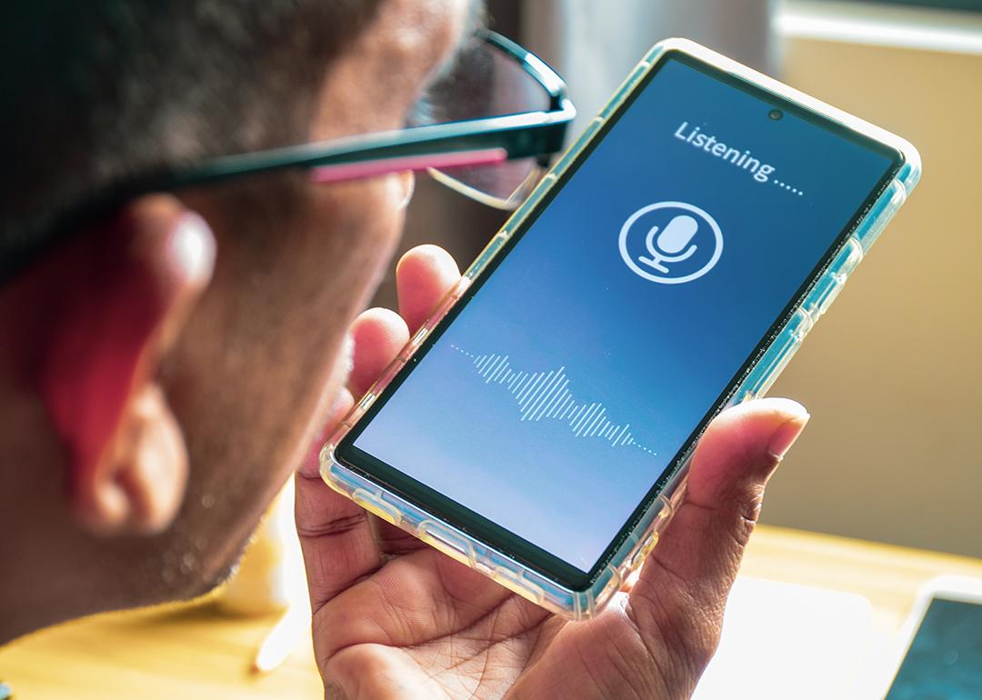 A man recording his voice on a phone. 