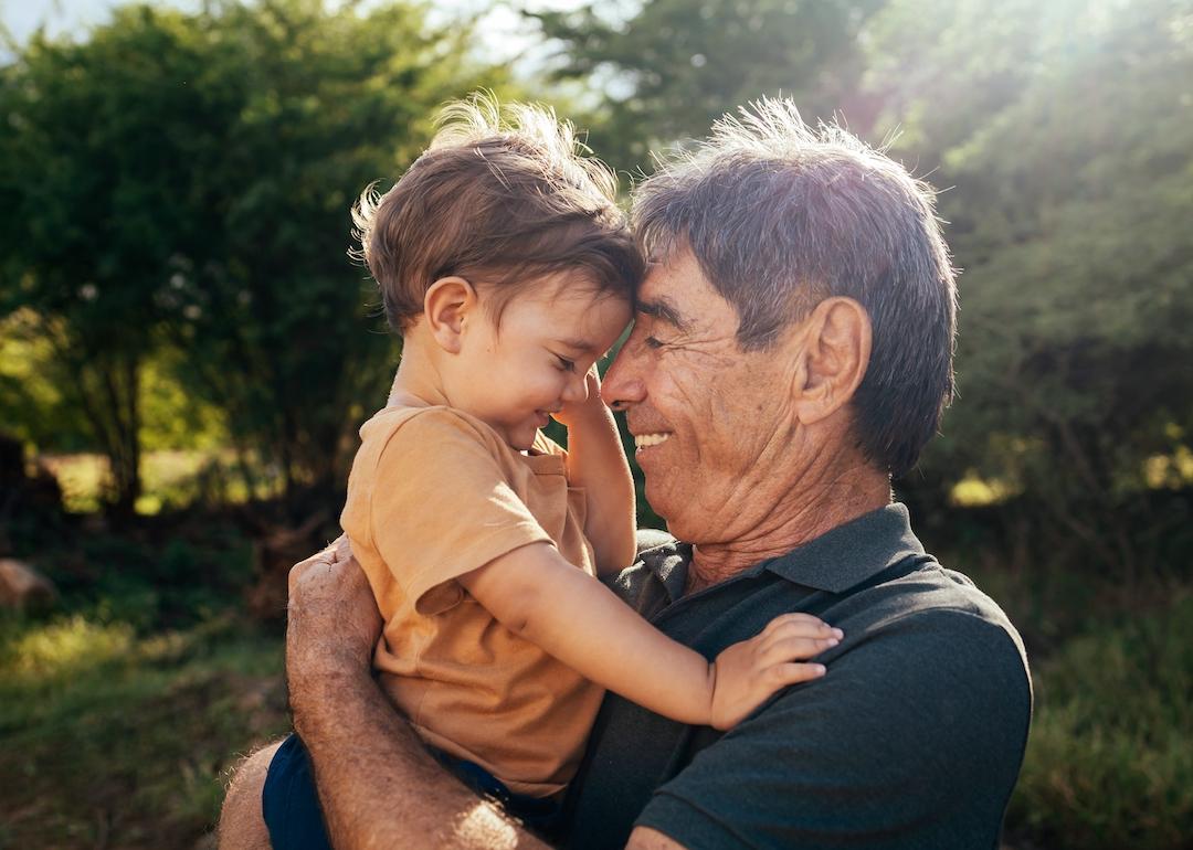 Grandparent spending time with grandchild in a park on a sunny day.