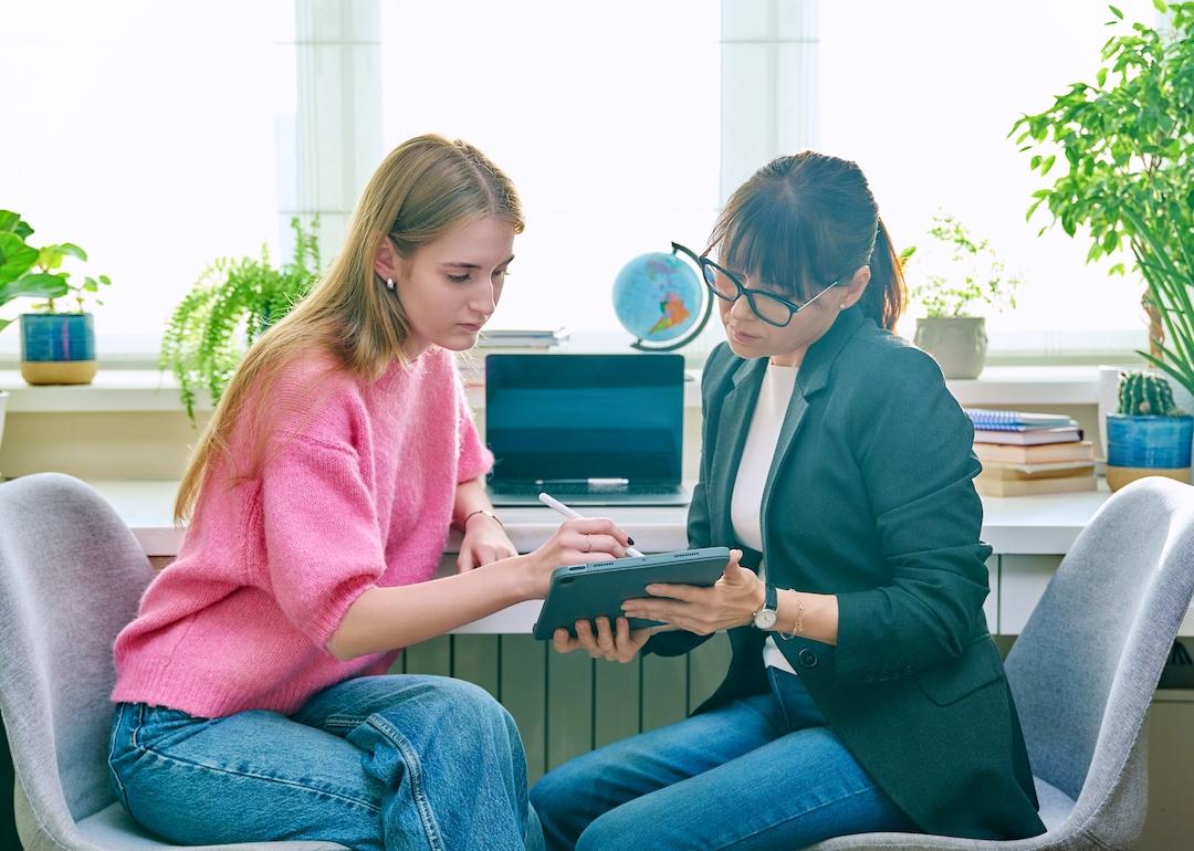 Counselor talking with teenager in office.