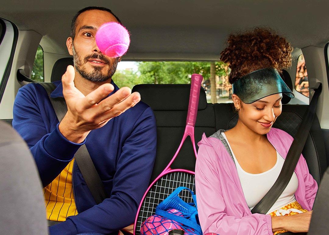 Two passengers wearing tennis outfits in the back of a rideshare vehicle.