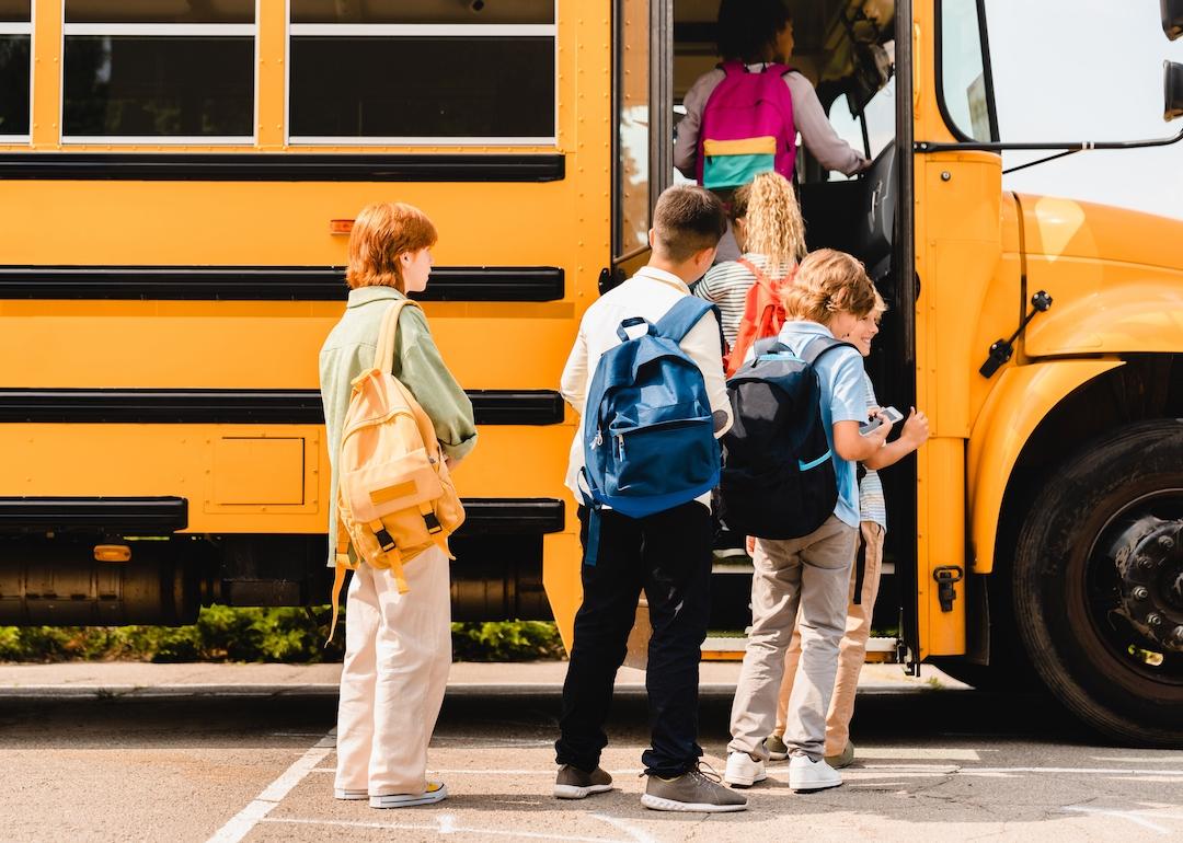 Children boarding school bus to public school.