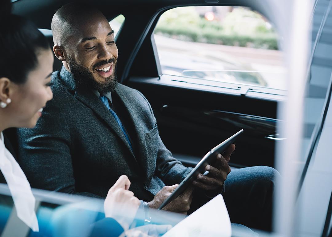 Two business professionals in a car ride going to a business meeting.