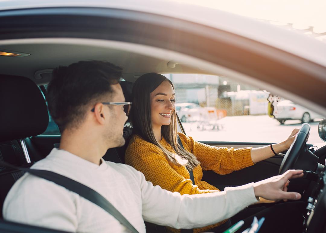 A man shows interior of car to prospective buyer.