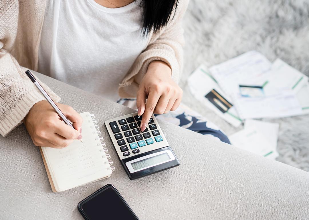 A woman calculating expenses and savings.