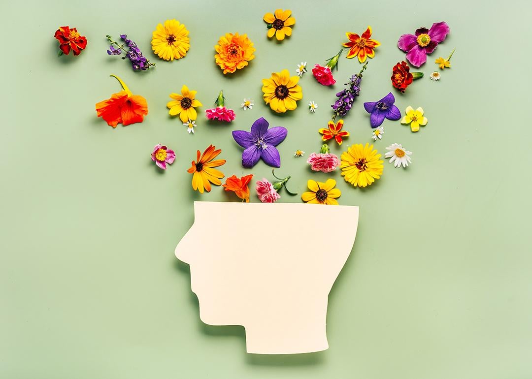 World mental health day concept showing different types of flowers blooming out of a head.