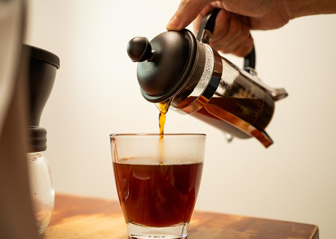 French press coffee being poured into a cup.